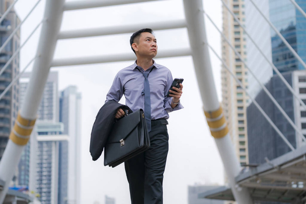 Ázsiai üzletember séta és a gazdaság táskát üzleti - Fotó, kép