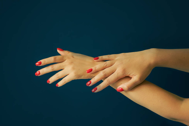 perfect red manicure. luxury nail and hand care in the salon. Black background - Foto, Imagen