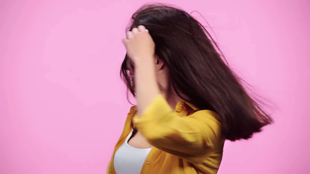 slow motion of air blowing in hair of beautiful girl shaking head and smiling isolated on pink - Metraje, vídeo