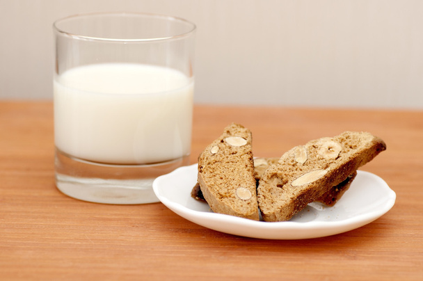 Вкусные печенье кантучини и стакан молока
 - Фото, изображение