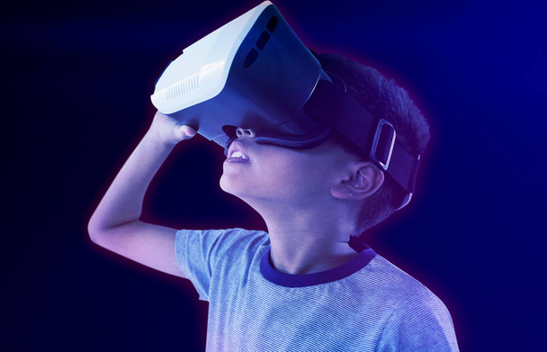 Close-up of boy wearing VR headset against gradient - Foto, imagen