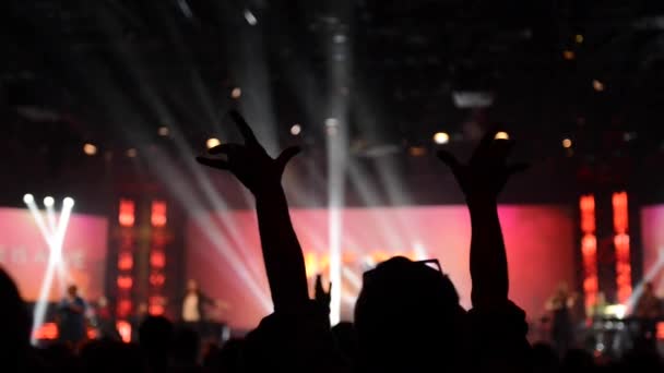Serviço de adoração com pessoas levantando as mãos com a luz do palco fora de foco
  - Filmagem, Vídeo
