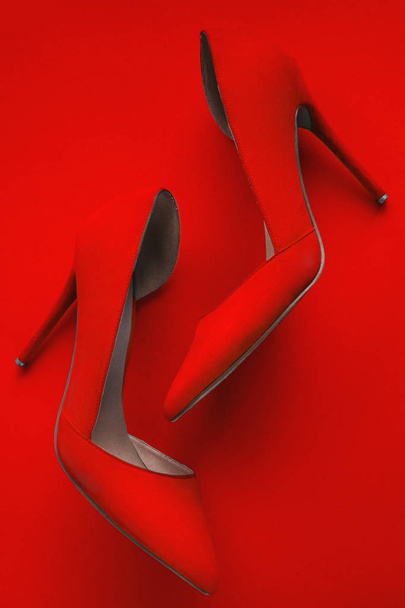 Photo of trendy fancy modern fashionable women luxury red pair of high heel shoes on a red background in studio - Zdjęcie, obraz