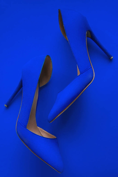 Photo of trendy fancy modern fashionable women luxury blue pair of high heel shoes on a blue background in studio - Foto, imagen