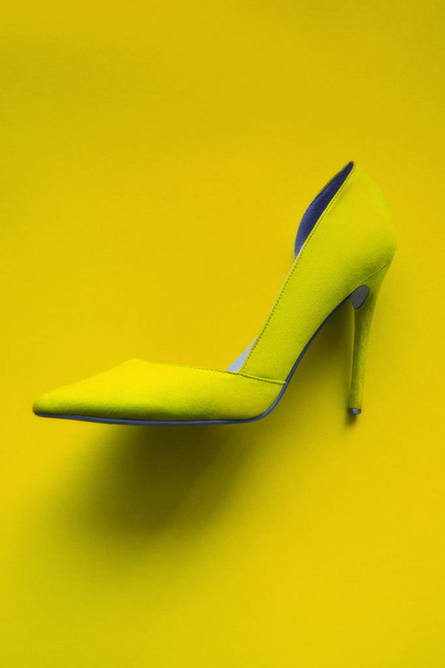 Photo of trendy fancy modern fashionable women luxury yellow high heel shoe on a yellow background in studio - Foto, immagini