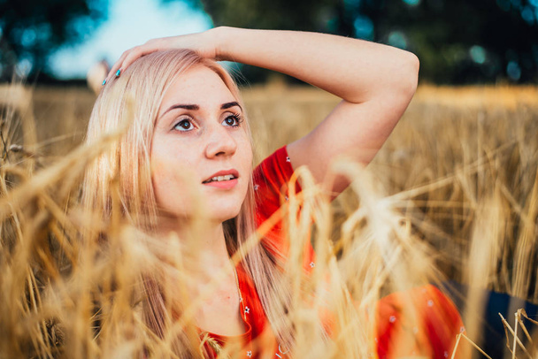 Beauty Girl Outdoors enjoying nature. Beautiful Model girl with long healthy blowing hair on the wheat Field. Toned in warm colors - Zdjęcie, obraz