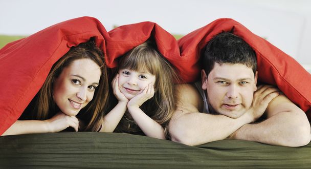 Happy family relaxing in bed - Фото, изображение