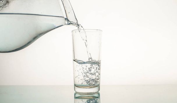 Close-up gieten gezuiverd vers drinkwater in het glas, close-up - Foto, afbeelding