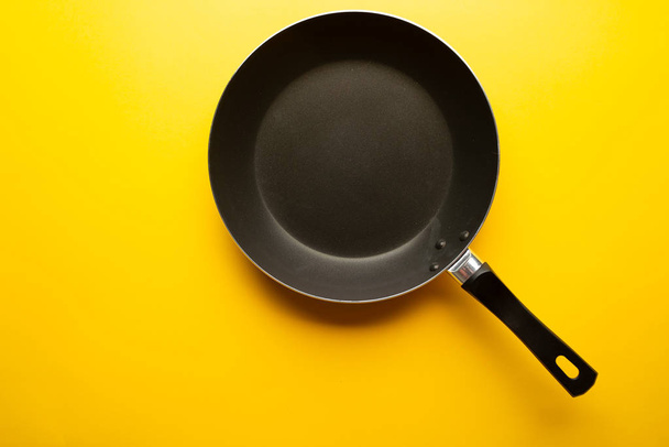 Empty pan on a yellow background - 写真・画像