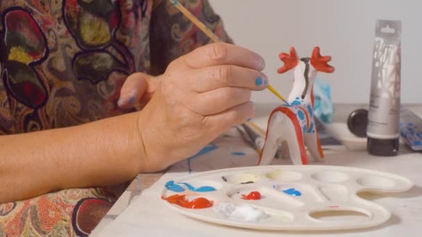 Starší žena, která maluje jelena - Záběry, video