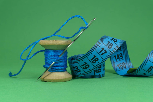 Голубая нить, рулетка и швейная игла
 - Фото, изображение