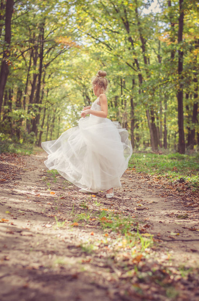 adorable child in long white wedding dress  - Foto, Imagen