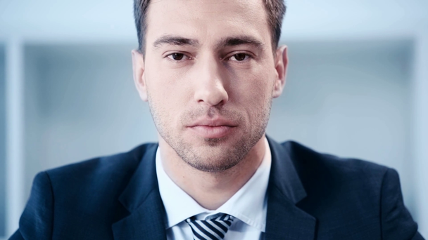slow motion of handsome, confident businessman looking at camera in office - Filmagem, Vídeo