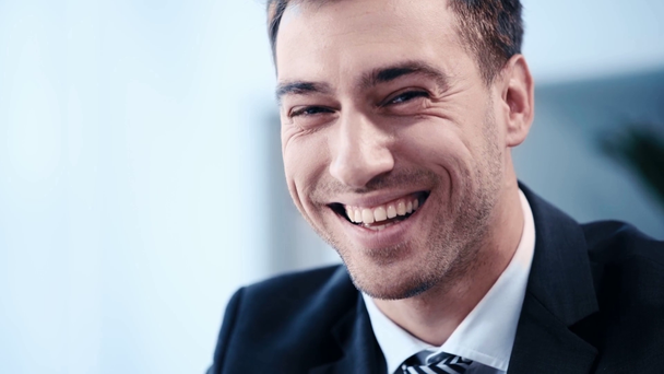 slow motion of positive, handsome businessman smiling while looking at camera - Záběry, video
