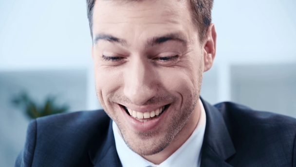красивий, щасливий бізнесмен сміється під час використання ноутбука в офісі
 - Кадри, відео