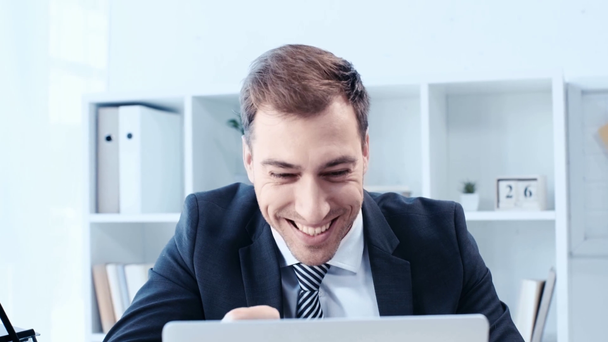 Veselý podnikatel používající laptopy v kanceláři, s úsměvem znázorňující gesto Yes - Záběry, video
