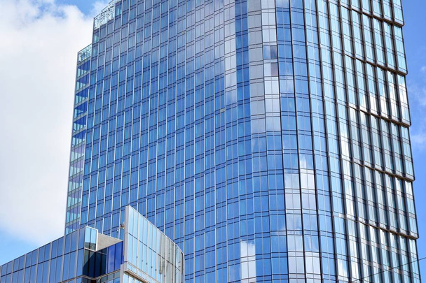 Novo edifício de escritórios no centro de negócios. Parede feita de aço e vidro com céu azul.  - Foto, Imagem