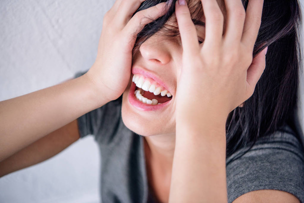 sconvolto donna bruna solitaria urlando e coprendo il viso a casa
 - Foto, immagini