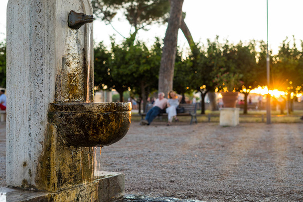 Hermosa fuente para beber contra el sol poniente en Roma, Italia
 - Foto, Imagen