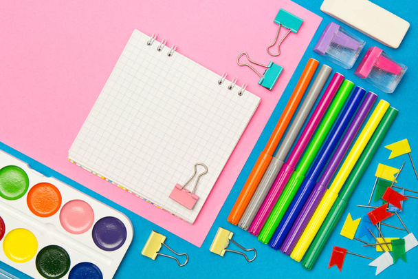 Briefpapier. School-en kantoorbenodigdheden op een blauwe en roze colore - Foto, afbeelding