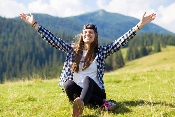 Happy excited girl with hands up looking at amazing view in the mountains - Foto, imagen
