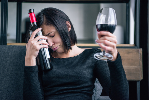 triste mujer solitaria con botella de vino y vidrio en casa
 - Foto, imagen
