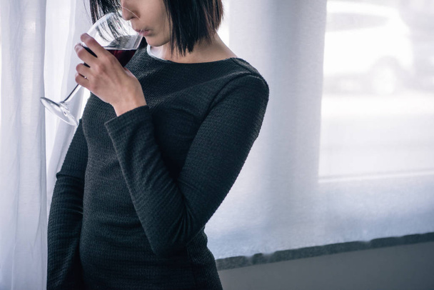 Cropped view of upset woman drinking wine at home - Foto, Bild