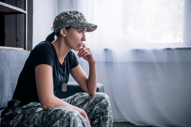пригнічена самотня жінка у військовій формі вдома
 - Фото, зображення