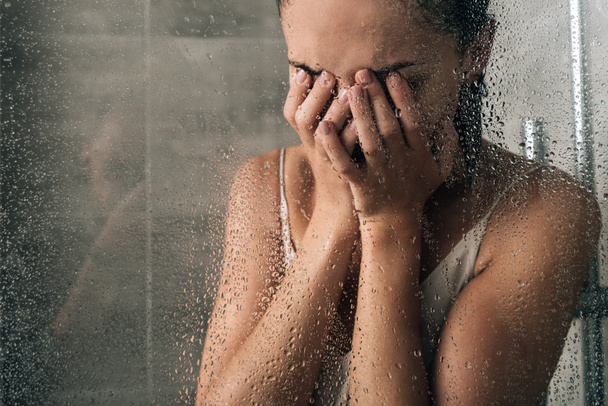 chateado mulher triste cobrindo rosto e chorando no chuveiro em casa
 - Foto, Imagem