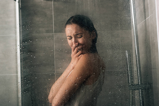 kaunis surullinen nainen peittää kasvot ja itkee suihkussa kotona
 - Valokuva, kuva