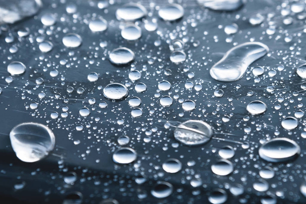 Close-up of raindrops of different sizes on the surface covered with cling film. Moisture weather and humidity concept - Fotoğraf, Görsel