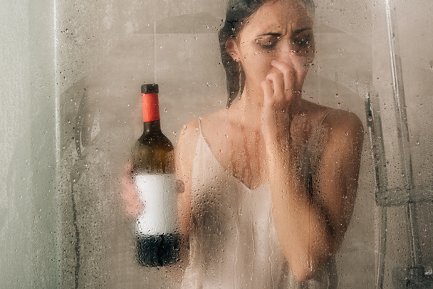 μοναχική κατάθλιψη γυναίκα στο ντους με μπουκάλι κρασί στο σπίτι - Φωτογραφία, εικόνα