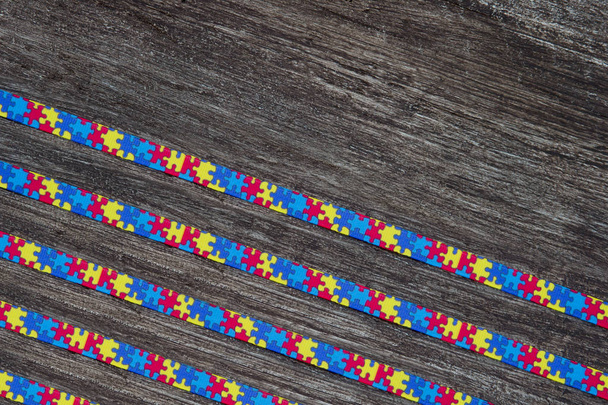 Wereld Autisme Awareness Day met puzzel lint op houten achtergrond - Foto, afbeelding