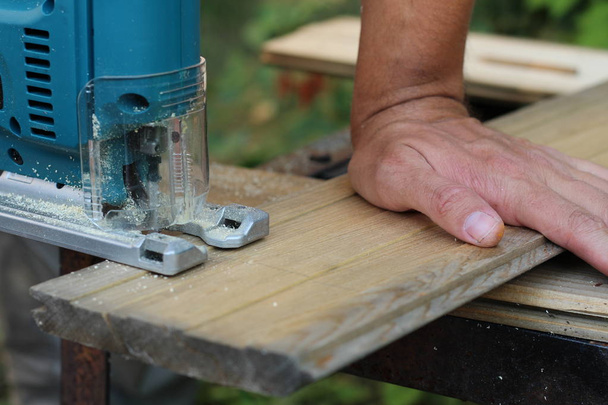 Carpenter with fretsaw at outdoor work. close-up - Photo, Image