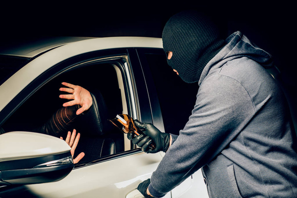 un hombre en una máscara de un ladrón con una botella rota en sus manos th
 - Foto, Imagen
