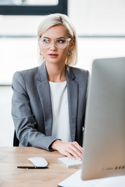 selective focus of beautiful businesswoman in glasses working in modern office  - Фото, изображение