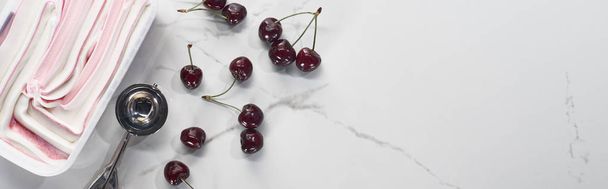 top view of delicious ice cream near ice cream spoon and cherries on marble grey background, panoramic shot - Fotografie, Obrázek