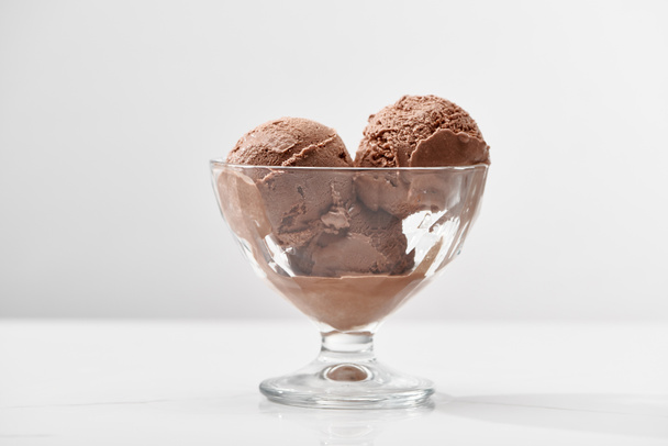 グレーに隔離されたガラスボウルのおいしいチョコレートアイスクリーム - 写真・画像
