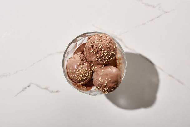 top view of delicious chocolate ice cream in bowl on marble grey background - Zdjęcie, obraz