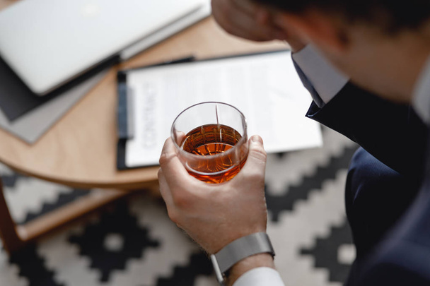 Close up of whisky in hand of man sitting - Φωτογραφία, εικόνα