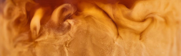 близкий вид коричневого кофе смешивания с белым молоком в стекле, панорамный снимок
 - Фото, изображение