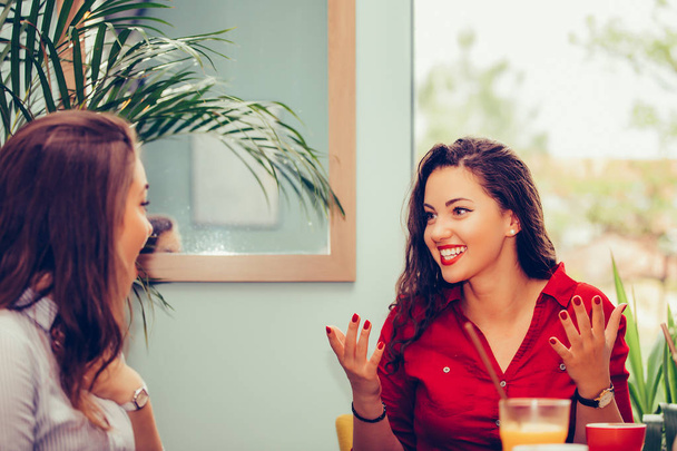 Szczęśliwy żeński przyjaciele rozmowa i picie Kawa podczas patrząc e - Zdjęcie, obraz
