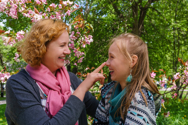 mother and daughter are talking and laughing in the park - Photo, Image