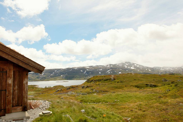 Havas hegyek és kék hideg ég a norvég fjord partján - Fotó, kép