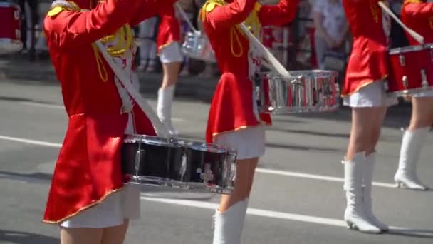 Chicas jóvenes baterista en rojo en el desfile. Primer plano de las manos femeninas bateristas están golpeando en el tambor de sus palos
 - Imágenes, Vídeo