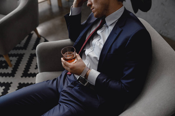 Tired man in suit leaning his head and drinking alcohol - Foto, Imagem