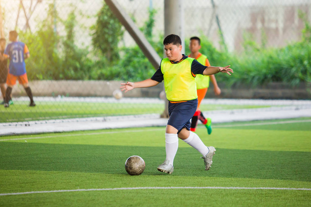 サッカー選手のスピードは、ボールtを撮影するために緑の人工芝で実行します - 写真・画像
