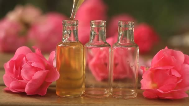 Ουσία του rose στο τραπέζι σε όμορφο γυάλινο μπουκάλι - Πλάνα, βίντεο