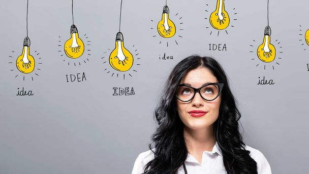 Idea light bulbs with young businesswoman - Photo, image