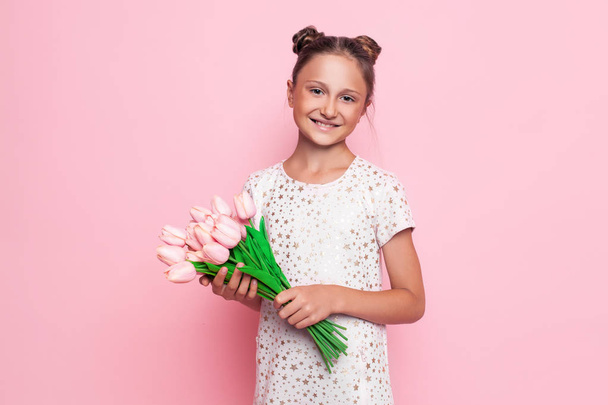 Portrait of a cute teenage girl in a stylish dress with a bouquet of flowers - Foto, Bild